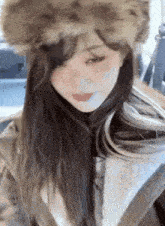 a close up of a woman wearing a fur hat and a coat .