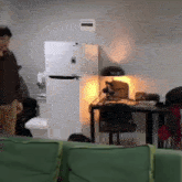 a man standing in a room with a green couch and a desk