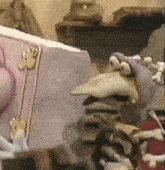 a cartoon character is standing next to a book with a bird on it .