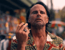 a man with a ring on his finger looks at the camera