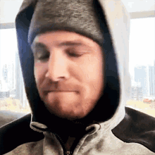 a close up of a man wearing a hooded jacket