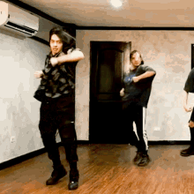 a group of people are dancing in a room with a door