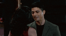 a man and a woman are kissing each other in a bar .