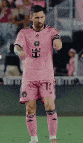 a soccer player wearing a pink jersey with the number 10 on the shorts