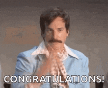 a man with a mustache is congratulating someone with his hands in the air .