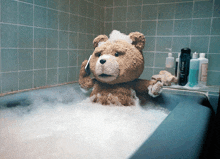 a teddy bear is taking a bath in a bathtub with axe shampoo