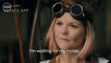 a woman is wearing goggles and says " i 'm waiting for my mates "