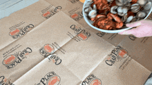 a person is holding a bowl of crawfish on a crab place bag
