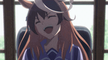 a girl with long brown hair is sitting in a chair smiling