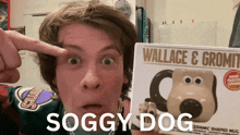 a man holds a wallace and gromit mug in his hand