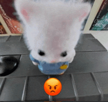 a stuffed animal with an angry face is sitting on a keyboard