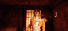 a woman in an orange sweater is dancing in a room