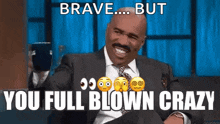a man in a suit and tie is making a funny face and says `` brave ... but you full blown crazy '' .