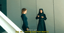 a woman in a nun 's robe is talking to another woman in a room .