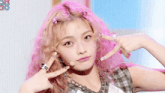 a girl with pink hair is wearing a plaid shirt and a necklace