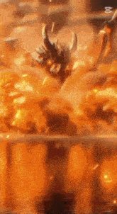 a bull with horns is flying through a fire .