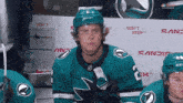 a hockey player sitting in front of a sign that says don 't stop