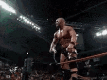 a shirtless wrestler is drinking milk from a cup .