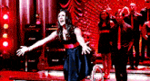 a woman in a black dress is screaming on a stage