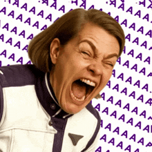 a woman in a purple and white jacket is screaming