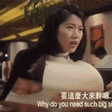 a woman with large breasts is sitting in a restaurant .