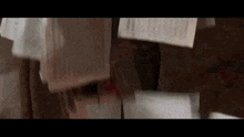 a person is standing next to a pile of papers on a wooden floor .