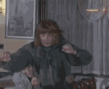 a man is carrying a woman on his back in a room with a sign that says zabava on it