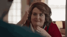 a woman is looking at herself in the mirror while a man touches her hair .