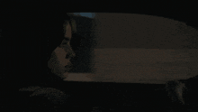 a woman is sitting in the back seat of a car at night .