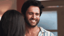 a man with a beard smiles at a woman