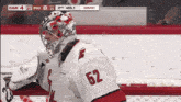a hockey player with the number 52 on his jersey stands in front of the net