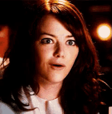 a close up of a woman 's face with her mouth open and a surprised look on her face .