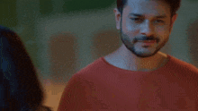 a man with a beard is looking at a woman .