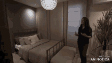 a woman stands in a bedroom with the words made in animotica on the bottom right