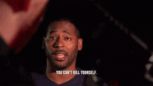 a man with a beard is talking to another man in a dark room .