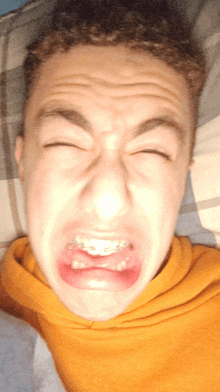 a young man making a funny face with his eyes closed