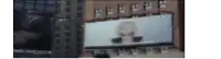a billboard on the side of a building with a woman 's face on it .