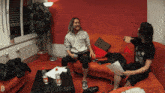 two people are sitting on a couch with one wearing a sweatshirt that says ' stun ' on it