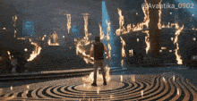 a man stands in front of a maze of flames with the hashtag avantika_0902 on the bottom