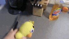 a person is cutting a stuffed animal with a knife next to a bag of salsas chips