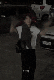 a man standing in a parking lot with a license plate that says 1676 5241