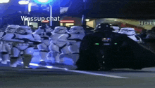 a group of stormtroopers are marching down a street with darth vader in the background