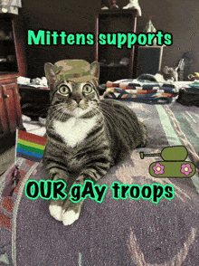 a cat wearing a military hat is laying on a bed with the words " mittens supports our gay troops " below it