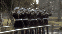 a group of soldiers are standing in a line with their guns up