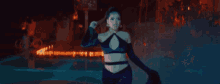a woman in a purple dress is dancing in front of a fire in a dark room .