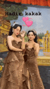 two women in dresses are standing next to each other in front of a painting with the words hadir kakak on the bottom