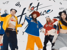 a group of young women are dancing in front of a wall that says " hot face "