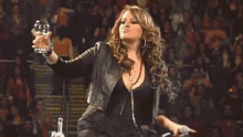 a woman is holding a glass of wine and a microphone while standing on a stage .