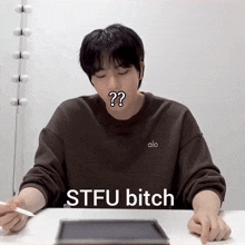 a man wearing an alo sweatshirt says stfu bitch in front of a tablet