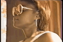 a close up of a woman wearing sunglasses and earrings with the letter w on her nose